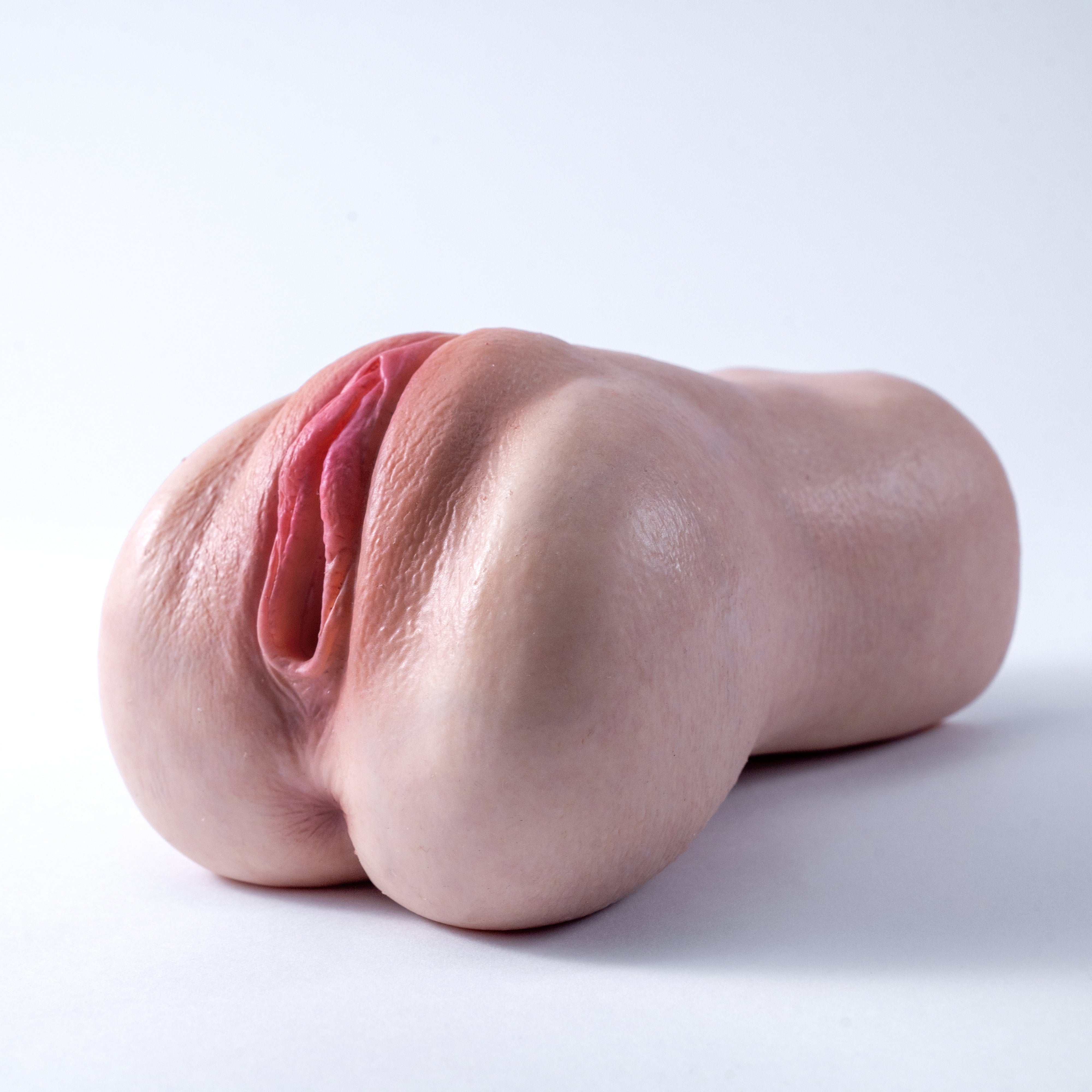 A handheld, lifelike vaginal masturbator featuring a realistic skin tone throughout, with lifelike skin texture and labia——Realistic Pocket Pussy Masturbator